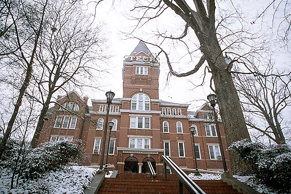 Seen at the top of a hill is the red brick building with the Georgia Tech tower rising above it